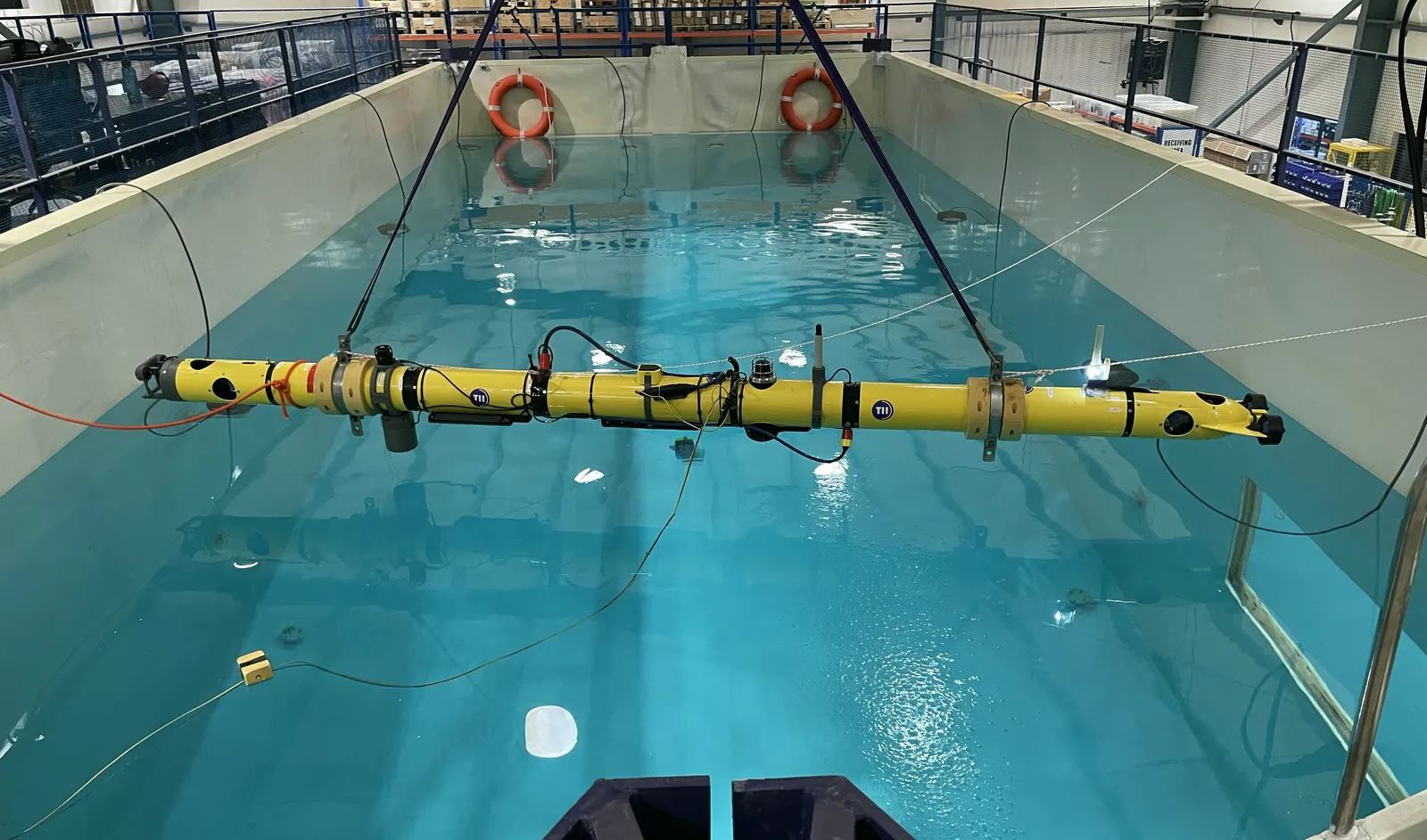 The X301 AUV, a modified GraalTech X-300, being lowered into the indoor test pool at TII.